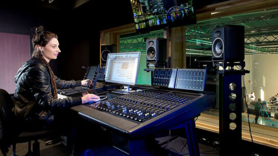 A girl who is adjusting the setting of the musical instruments.