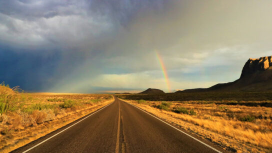 View of rainbow, mountain, and road.