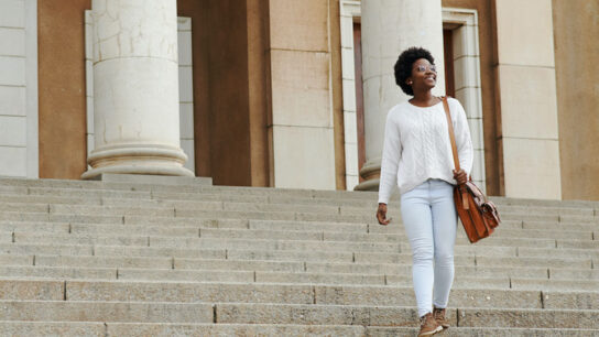 Female student step down the building stairs.