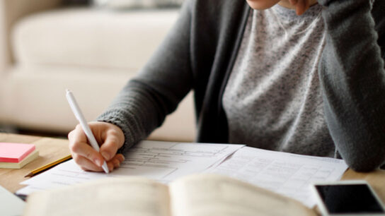 Female student is writing on paper.