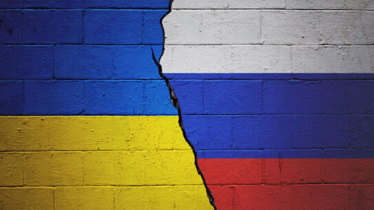 Flags of Ukraine and Russia painted on cracked wall