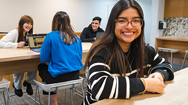 students smiling in campus kitchen lunch area