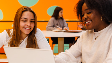 Students on campus collaborating on laptops