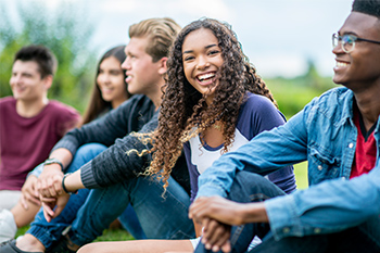 Group of students sitting outside smiling