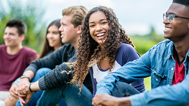 Group of students sitting outside smiling